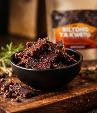 Bol noir rempli de lamelles de bœuf séché Biltong ya Kwetu, paquet en arrière-plan